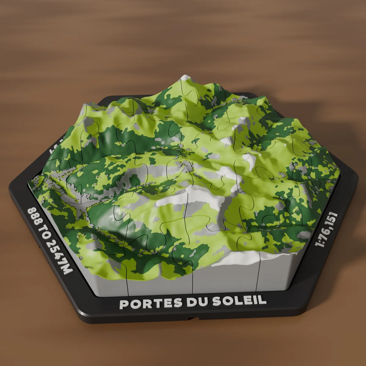 3D printed hexagonal map jigsaw of Avoriaz in green, lime, grey and white, in a black tray on a wooden table