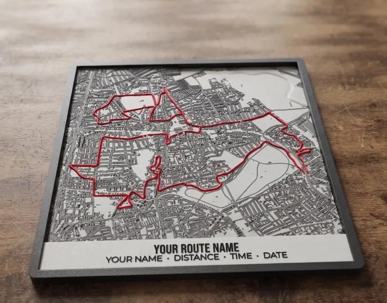 White 3D printed route map plaque with a red route, on a wooden table